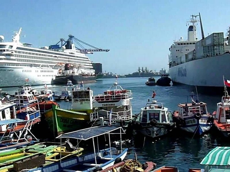 Small fishing boats moored in front of a naval vessel at the Valparaiso waterfront