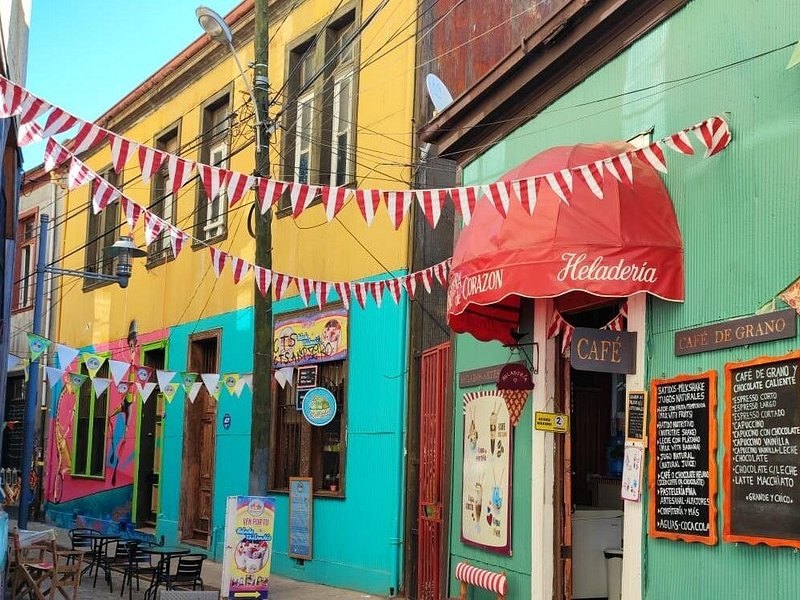 A green and yellow corner building hung with bunting on a Valparaiso side street