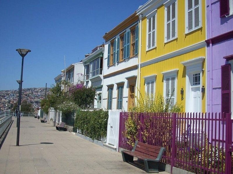 A quiet paseo lined with pastel houses, the bay showing at the end of the street