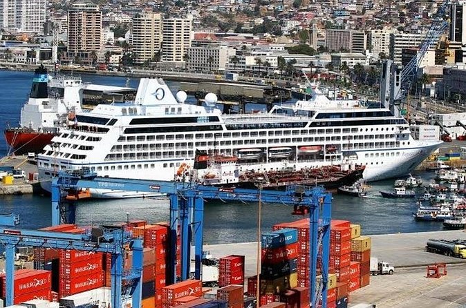 Stacked shipping containers along the quay at Valparaiso with a passenger ship alongside