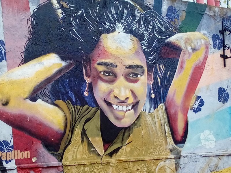 A large painted portrait covering a wall in the hills of Valparaiso